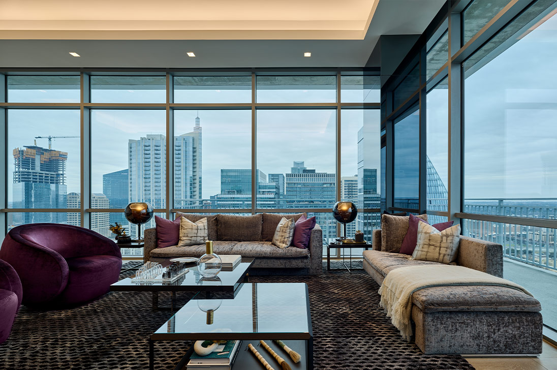 City living room with warm cove lighting and window shades — from Lutron’s image gallery